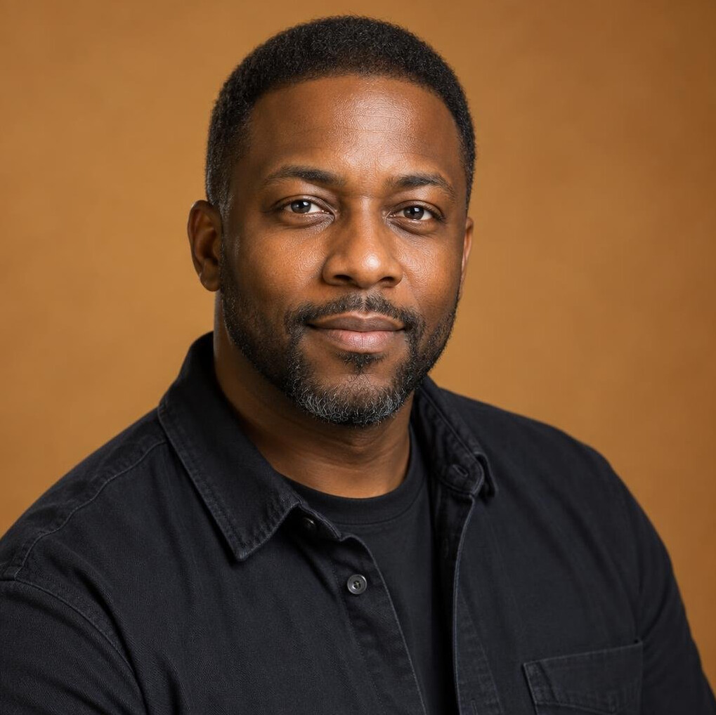 Professional headshot of a Black British man lighting director